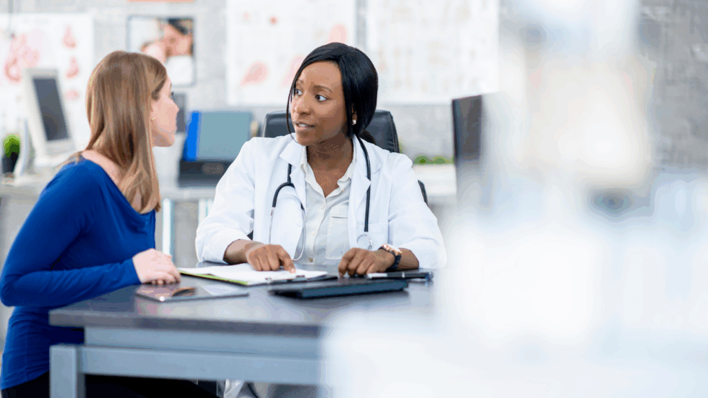 Photorealistic image of a physician discussing treatment progress with a patient in a clinical office, representing supervised medical trials-assisted psychotherapy outcomes and patient care
