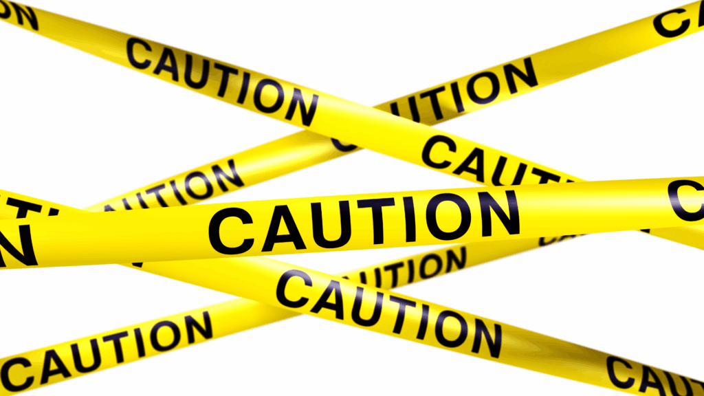 Yellow caution tape crossing over a white background symbolizing safety warnings, risk awareness, and precautionary guidance related to turmeric use and interactions